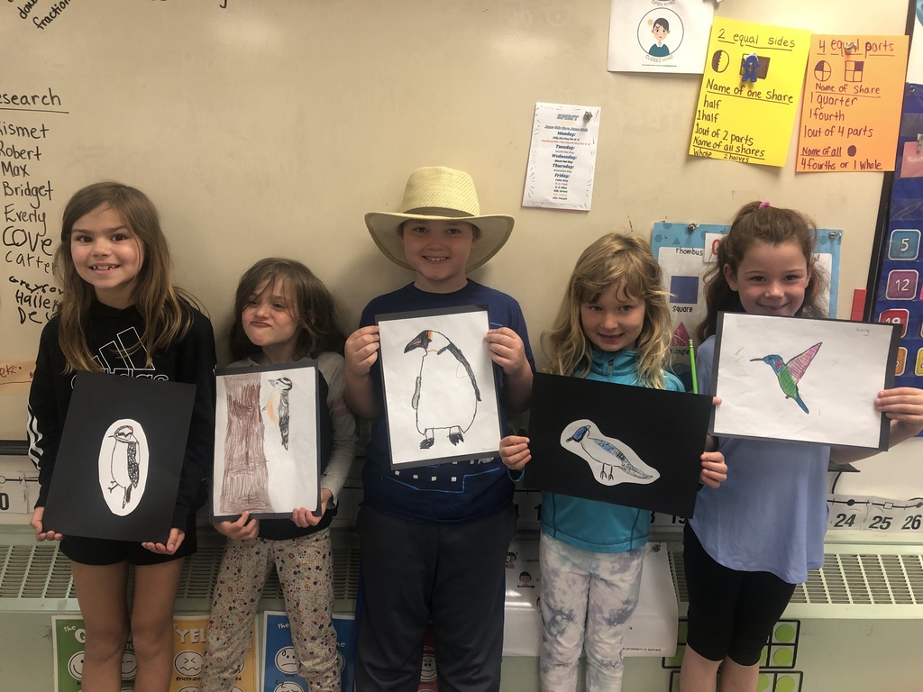 Students showing their bird drawings